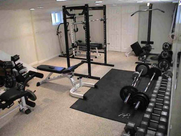 fully equipped basement gym with lat pulldown, rack, benches and dumbbells